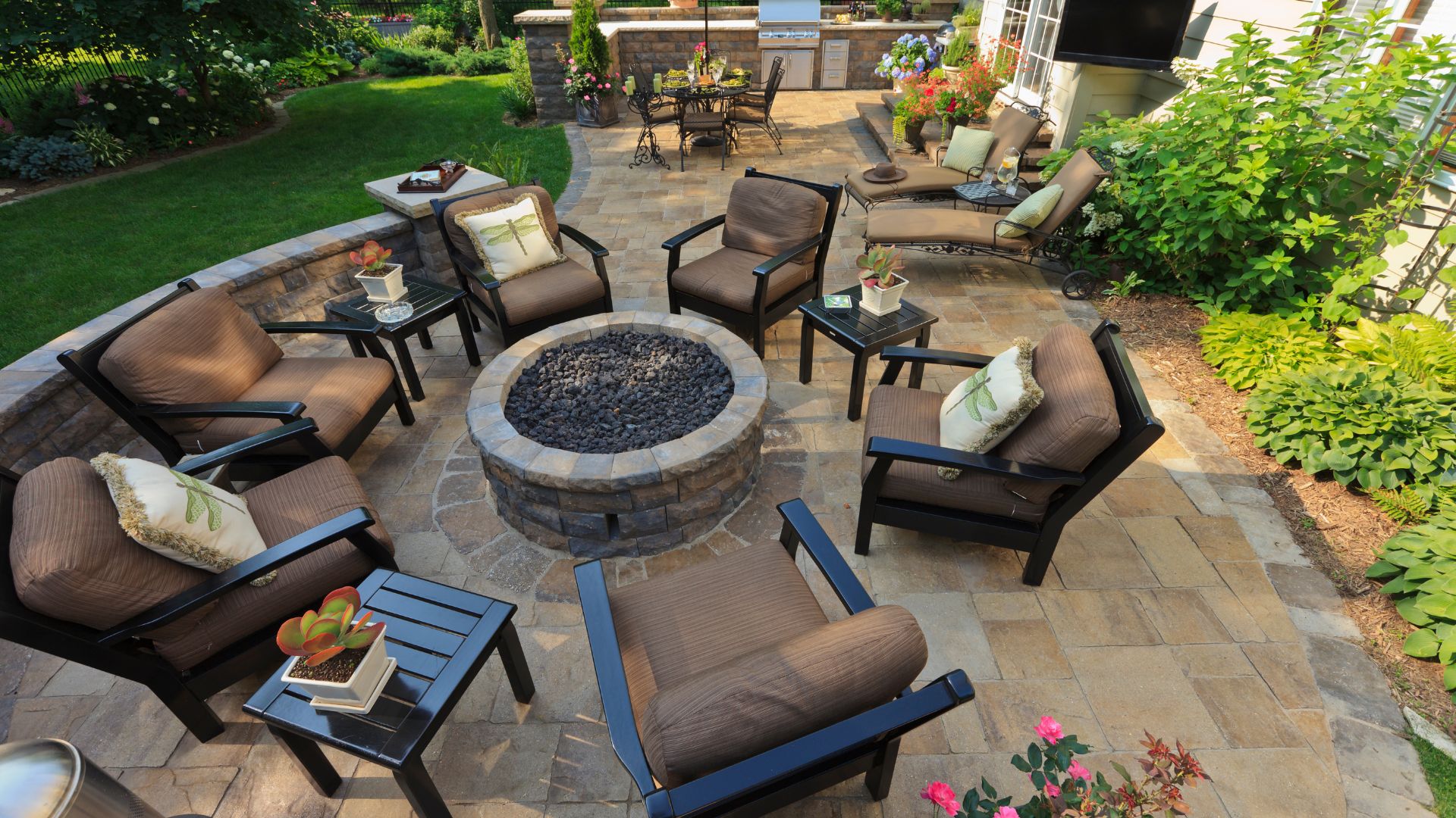 Luxurious outdoor patio with fire pit, seating, and landscaped garden
